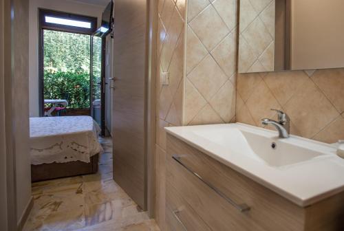een badkamer met een witte wastafel en een raam bij Venere B&B Castelmola in Castelmola