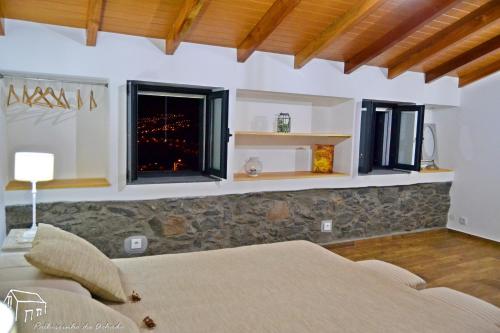 a bedroom with a bed and a window at Palheirinho da Achada in Arco da Calheta
