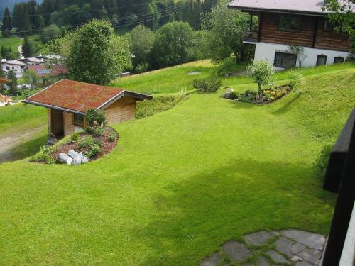 a green yard with a house on a hill at Haus Anne in Ellmau