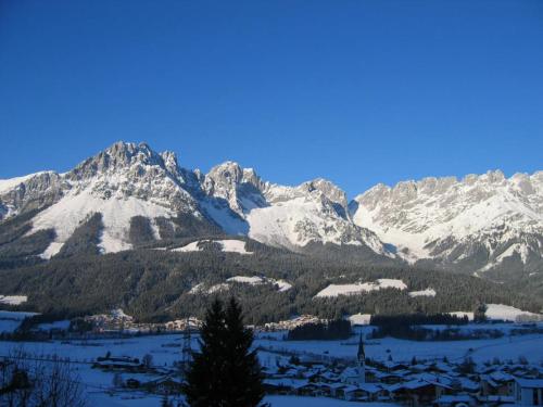 a snow covered mountain range with a village in the foreground at Haus Anne in Ellmau