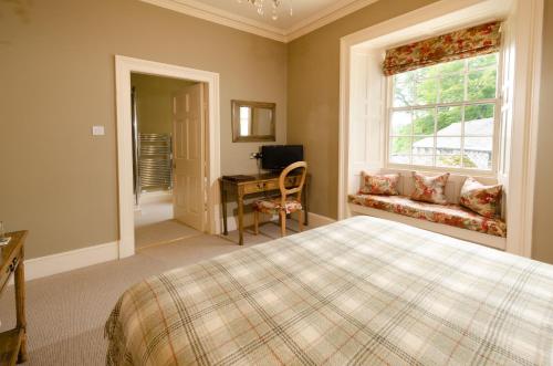 a bedroom with a bed and a window and a desk at Eltermere Inn in Elterwater