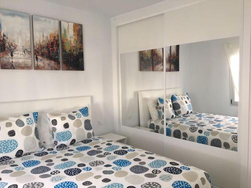 sypialnia z dwoma łóżkami z niebieskimi i białymi poduszkami w obiekcie Los Gracioseros 118 & 202 w Puerto del Carmen