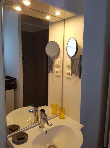 une salle de bain avec un lavabo blanc et un miroir dans l'établissement Jolie petite maison idéalement située, à Arles