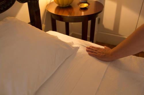 a person putting their hand on a pillow on a bed at Casa De Casal De Loivos in Pinhão