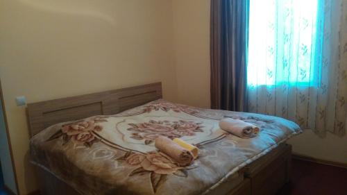 ein Bett in einem Schlafzimmer mit einem Blumenmuster darauf in der Unterkunft Zukas Hause in Achalziche