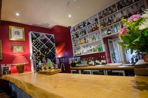 a bar with a counter and a lot of bottles at Eltermere Inn in Elterwater