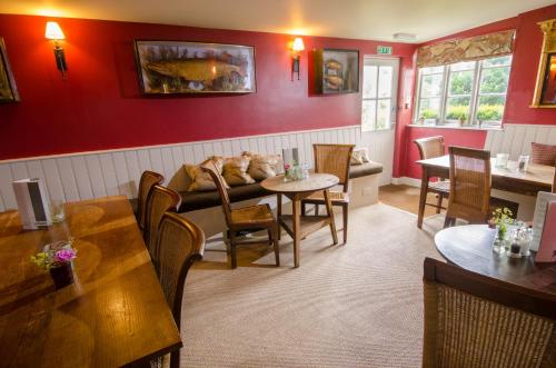 a restaurant with a couch and tables and chairs at Eltermere Inn in Elterwater
