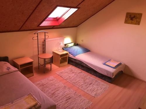 1 Schlafzimmer mit 2 Betten, einem Schreibtisch und einem Fenster in der Unterkunft Vadvirág vendégház in Lenti