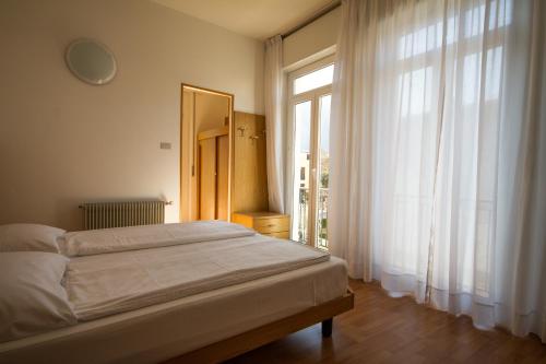 a bedroom with a bed and a large window at Villa Orchidea in Nago-Torbole