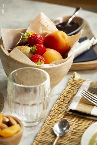a wooden bowl of fruit sitting on a table at Le 19-21 - Un amour d'hotel in Leucate