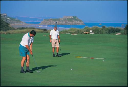 dos hombres están jugando golf en un campo de golf en Marlborough Guest House B & B, en Tenby