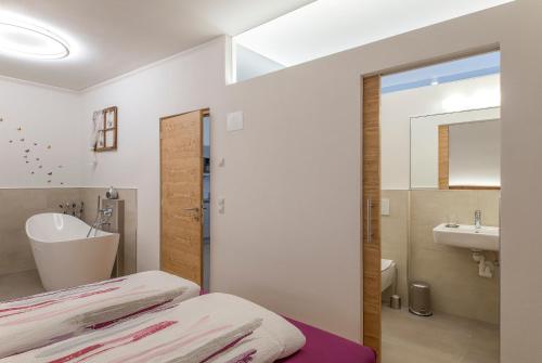 uma casa de banho com uma cama, um lavatório e um espelho. em Ansitz Mairhof em Parcines