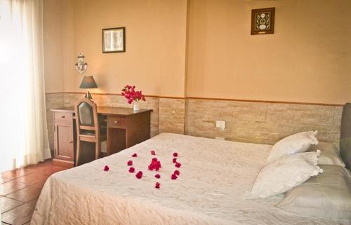 1 dormitorio con 1 cama con pétalos de rosa rojo en Casa Buganvilla, en Los Realejos