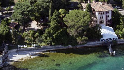 an aerial view of a house next to a body of water at Hotel Villa Fiordaliso in Gardone Riviera