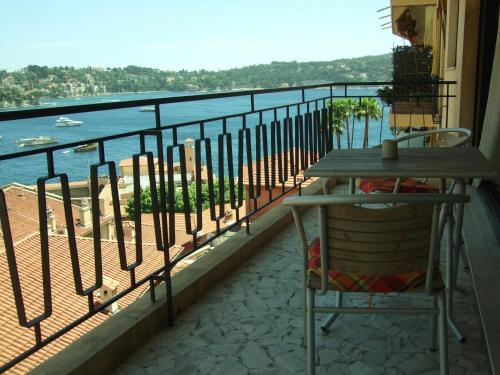 a balcony with a table and a view of the water at The Dina Palace. in Villefranche-sur-Mer