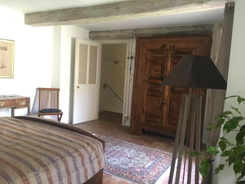 - une chambre avec un lit et une porte en bois dans l'établissement Maison de village Novissime, à Noves