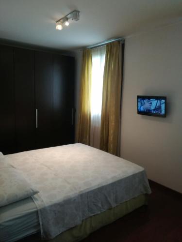 um quarto com uma cama e uma janela com uma televisão em Milano Greco appartamento em Milão