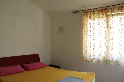 un dormitorio con una cama y una ventana en Apartments Durutović, en Bar