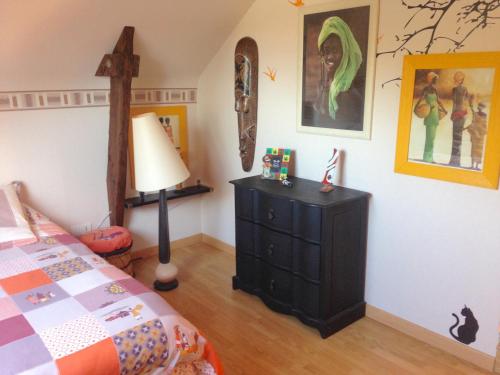 - une chambre avec un lit et une croix sur le mur dans l'établissement Blandine & Christian, à Saint-Judoce