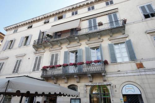 - un bâtiment avec balcon et fleurs rouges dans l'établissement Residenza d'Epoca Montanini, à Sienne