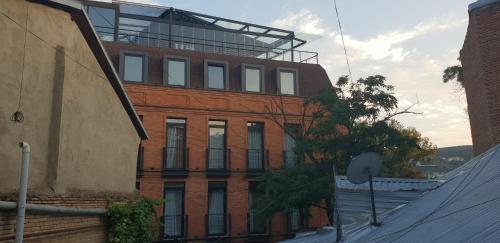 a brick building with a balcony on top of it at 2 Santeli Turn Guest House in Tbilisi City