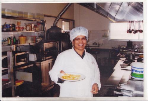 a man in a kitchen holding a plate of food at Grace Villa Bentota in Bentota
