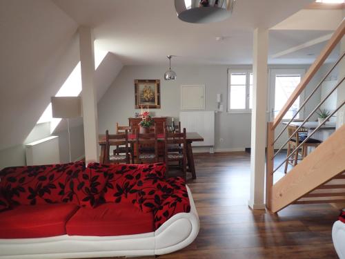 a living room with a red couch and a table at Les Gîtes de la tour, appartement "le Vignoble" in Saint-Hippolyte