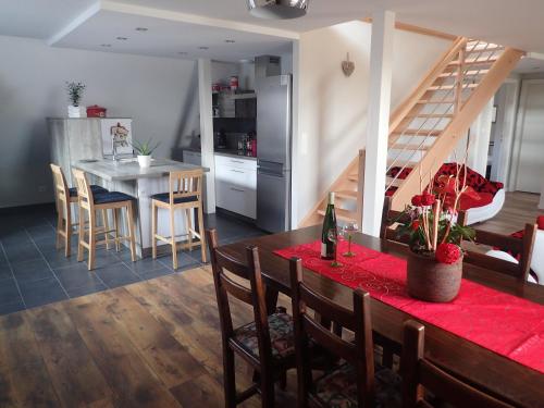 une cuisine et une salle à manger avec une table et une cuisine avec un escalier dans l'établissement Les Gîtes de la tour, appartement 