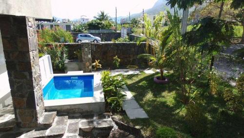 a backyard with a swimming pool in a yard at Le Morne Kite Villas in La Gaulette