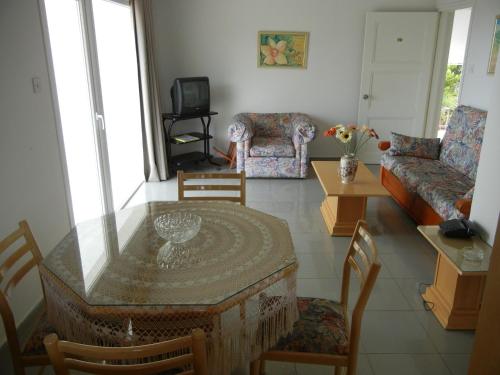a living room with a table and a couch at Tsialis Hotel Apartments in Larnaka