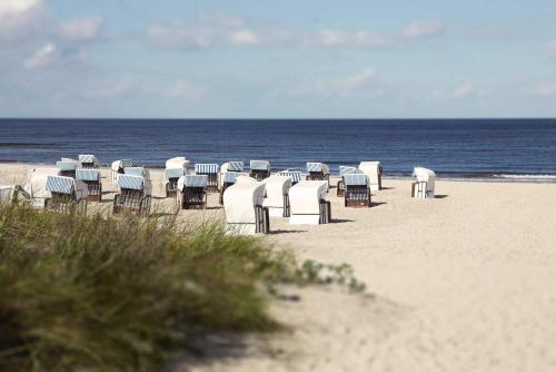a group of chairs and tables on a beach at Strandnest Büsum in Büsum
