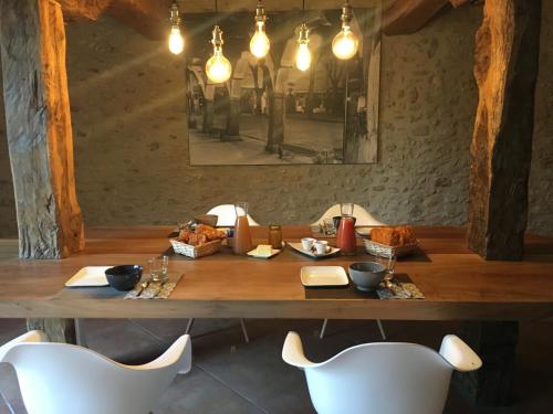 - une table avec des chaises blanches et une table avec de la nourriture dans l'établissement Chambres Ambroisie, à Gueytes-et-Labastide