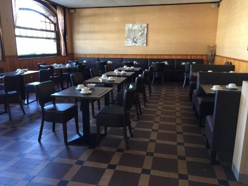a dining room filled with tables and chairs at Hôtel Moderne in Gisors