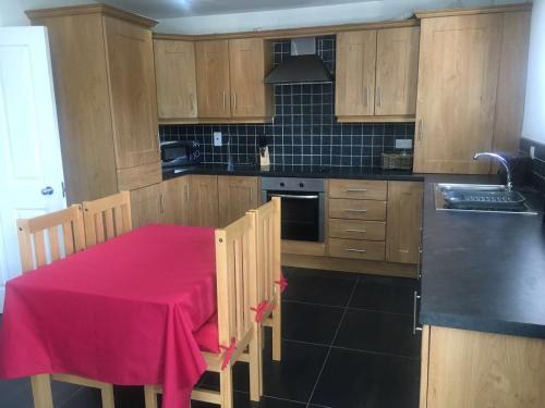 a kitchen with a table with a pink table cloth on it at 5 Shell Hill Mews in Coleraine