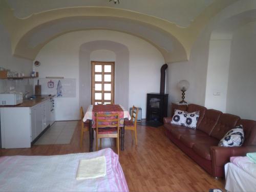 ein Wohnzimmer mit einem Sofa und einem Tisch sowie eine Küche in der Unterkunft Dvůr v Borovné in Borovná