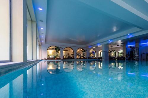 una grande piscina in un edificio con piscina di Admiral Hotel Villa Erme a Desenzano del Garda