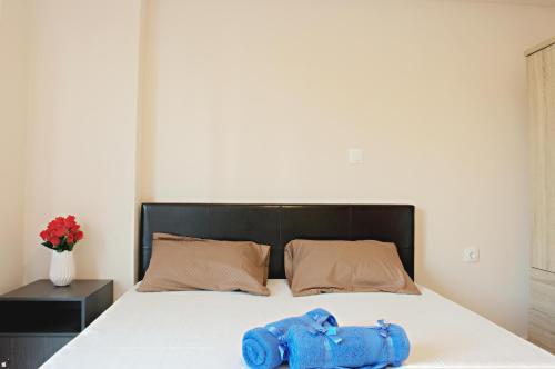 a bed with two blue shoes on it at Spiridoula's Apartments Corfu in Perama