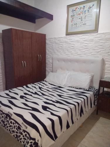 a zebra print bed in a bedroom with a wall at Mate de luna in Buenos Aires