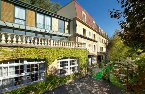 a building with ivy growing on the side of it at Hôtel Restaurant Plaisance-Piscine couverte et chauffée- Proche Sarlat- in Vitrac