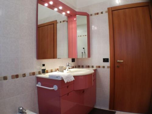 een badkamer met een rode wastafel en een spiegel bij B&B SARI in Como