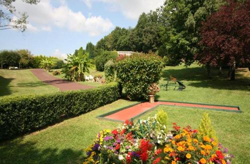 a garden with many flowers and bushes and trees at Hôtel Restaurant Plaisance-Piscine couverte et chauffée- Proche Sarlat- in Vitrac
