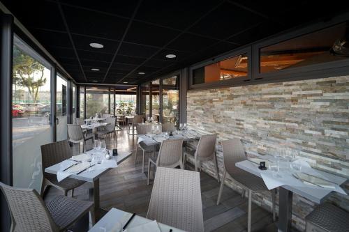 a restaurant with tables and chairs and a brick wall at Hotel Ibis Budget Nice Palais Nikaia in Nice