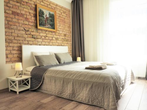 a bedroom with a bed and a brick wall at Emi apartment in Vilnius