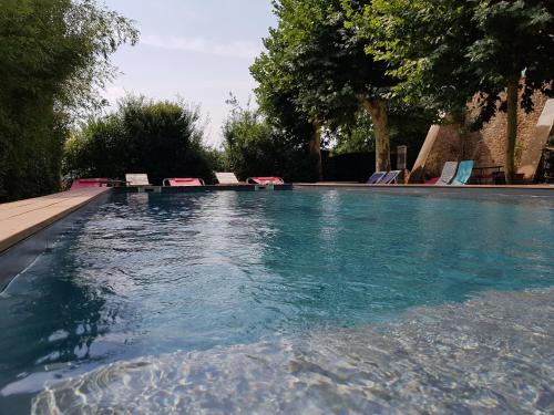 - une piscine avec des chaises dans l'eau dans l'établissement Domaine Saint Dominique, à Saint-Maximin-la-Sainte-Baume