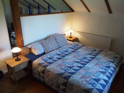 KollmarにあるHaus am Deichのベッドルーム1室(ベッド1台、テーブルにランプ2つ付)