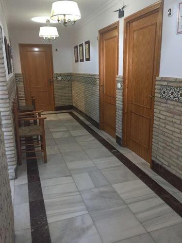 a hallway with wooden doors and a chair in a building at Casa Francisco el de Siempre in El Palmar