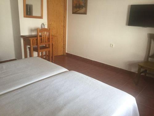 a bedroom with a bed and a table and a chair at Casa Francisco el de Siempre in El Palmar