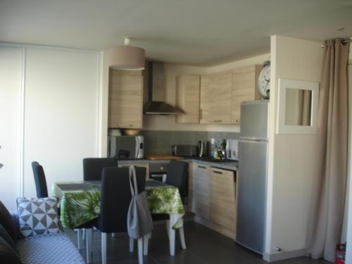 Il comprend une cuisine équipée d'un réfrigérateur et d'une table avec des chaises. dans l'établissement Studio Centre Ville Office De Tourisme, à Bayonne