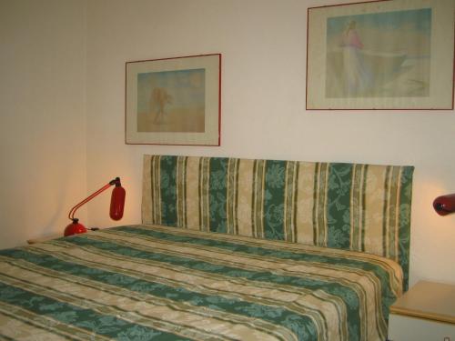 1 dormitorio con 1 cama con manta y lámpara en Residence Portofino Est, en Rapallo