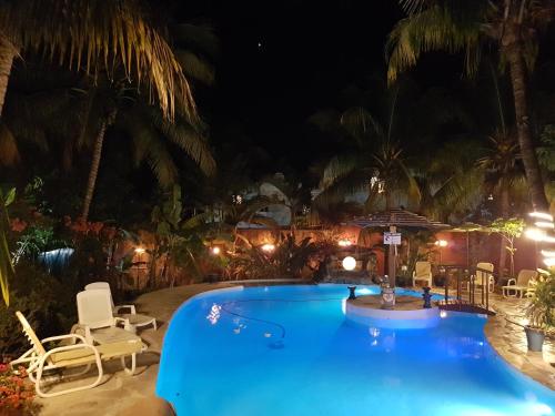 a pool at night with chairs and palm trees at Villa Tourelle of Paradise with bigPrivate Pool in Rivière Noire